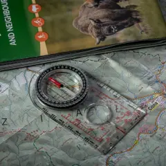 Mapa turystyczna z Bieszczad, na niej leży busola a kompas, gotowe do wyprawy.