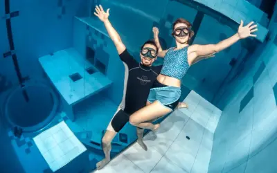 Para, która cieszy się freedivingiem, czyli nurkowaniem na wstrzymanym oddechu, w basenie głębinowym.