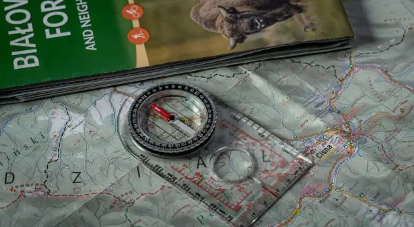 Mapa turystyczna z Bieszczad, na niej leży busola a kompas, gotowe do wyprawy.